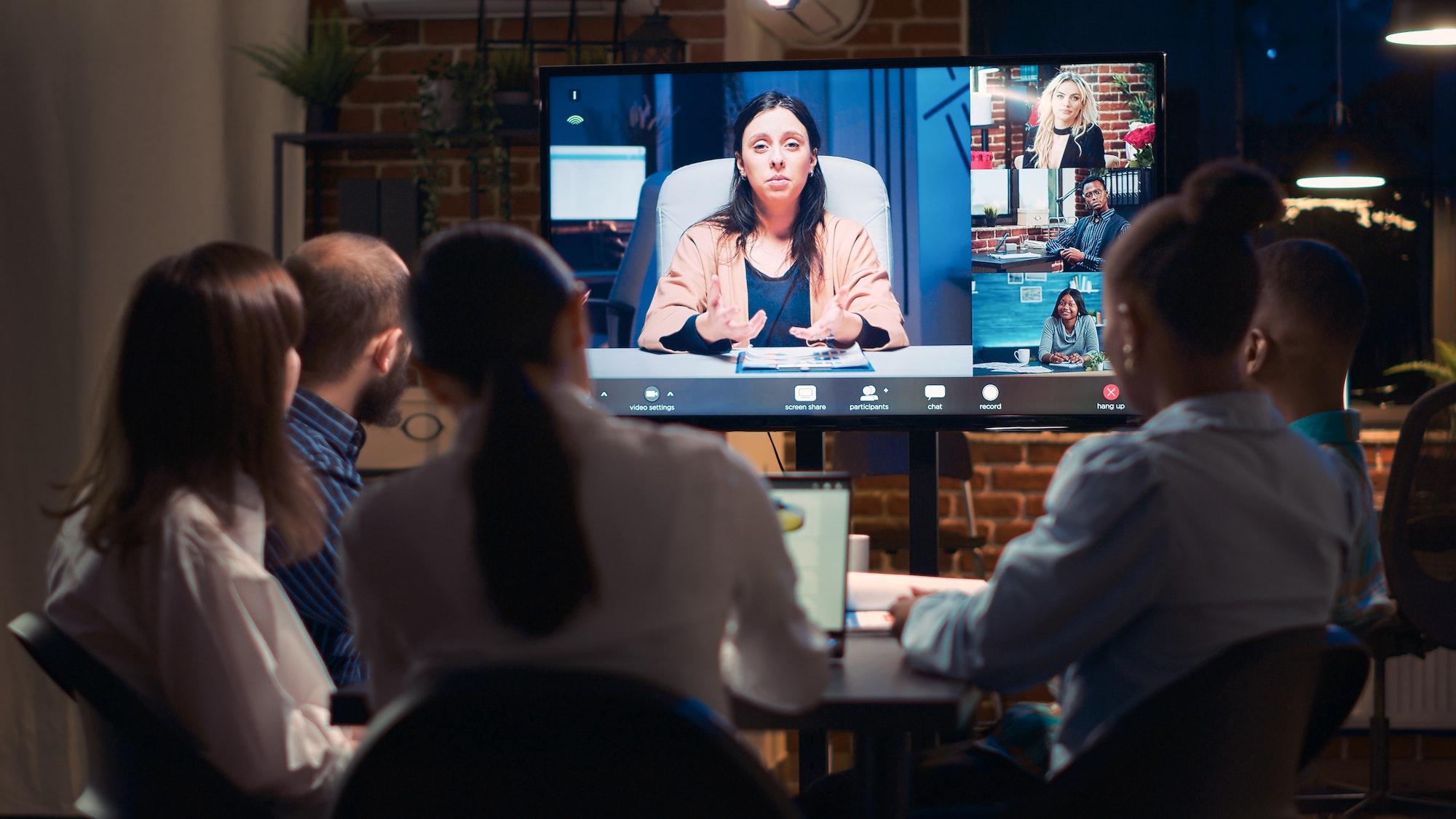 Employees listening to remote coworker in videocall conference